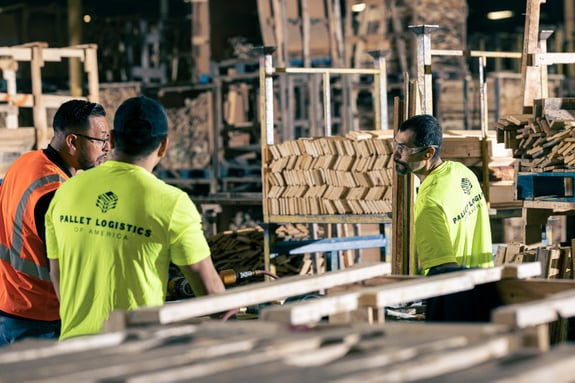 Three PLA employees inside a warehouse